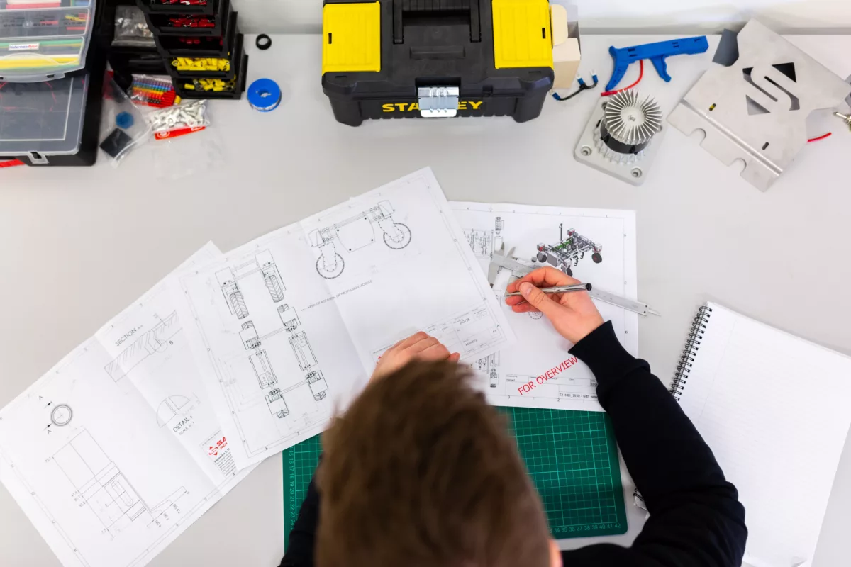 image shows engineer working with schematics at a testing workbench